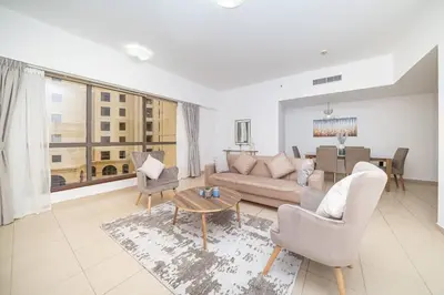 a living room with a couch and chairs and a table at StoneTree - Spacious 2 BR near JBR beach in Dubai