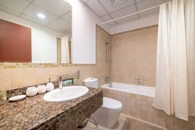 a bathroom with a sink and a toilet and a tub at StoneTree - Spacious 2 BR near JBR beach in Dubai
