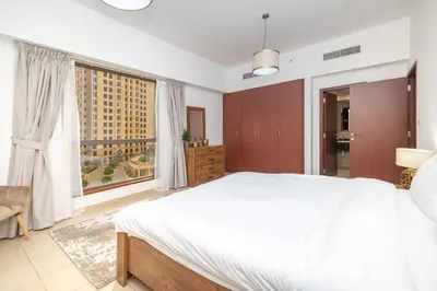a bedroom with a large white bed and a large window at StoneTree - Spacious 2 BR near JBR beach in Dubai