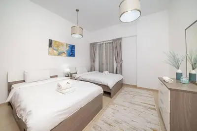 a hotel room with two beds and a desk at StoneTree - Spacious 2 BR near JBR beach in Dubai