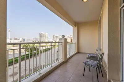 a balcony with two chairs and a view of the city at ALiving Elegant & Cozy 1BR I Mazaya 11, Liwan in Dubai