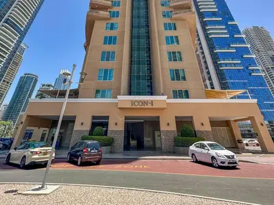 two cars parked in a parking lot in front of a hotel at StoneTree - Cozy Fully-Furnished Studio in JLT in Dubai