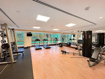 a gym with several treadmills and machines in a room at StoneTree - 1BR apartment with Lake View in Dubai