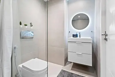 a bathroom with a toilet and a glass shower at StoneTree - Stylish Apartment with amazing building facilities in Dubai