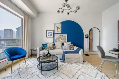 a living room with a couch and a table and chairs at GuestReady - Luxurious Marina view residence in Dubai