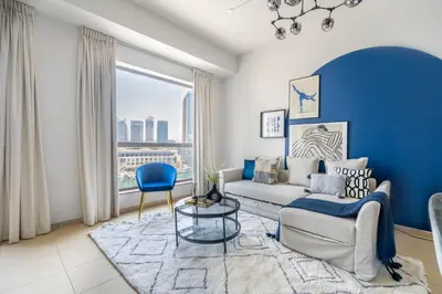 a living room with a couch and a blue wall at GuestReady - Luxurious Marina view residence in Dubai