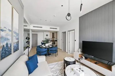 a living room with a white couch and a tv at StoneTree - Modern Living in Dubai Marina in Dubai