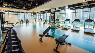 a gym with treadmills and elliptical machines at StoneTree - Modern Living in Dubai Marina in Dubai