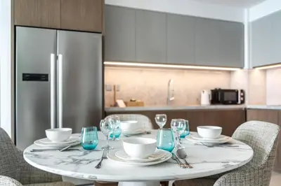 a white table with chairs and a refrigerator in a kitchen at Sea view 2-Bedroom - Beach Isle in Dubai