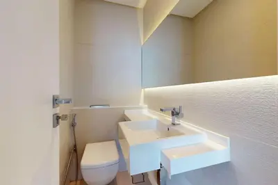 a bathroom with a white sink and a toilet at West Avenue - Chic One Bedroom in Dubai
