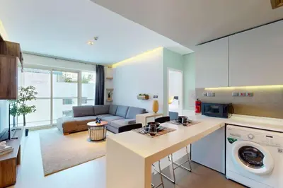 a kitchen and living room with a couch at West Avenue - Chic One Bedroom in Dubai