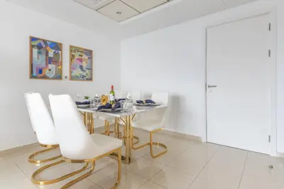 a dining room with a table and white chairs at Frank Porter - Bay Central 1 in Dubai