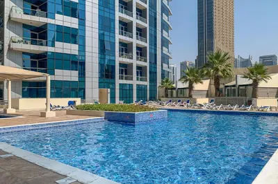 a large swimming pool in front of a tall building at Frank Porter - Bay Central 1 in Dubai