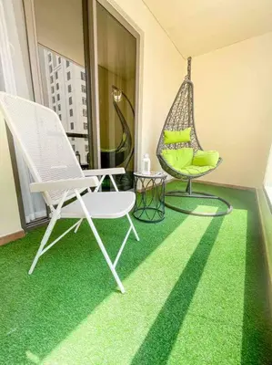a room with a hammock and a chair on a balcony at Bahar JBR Apartment by HAPPY SEASON in Dubai