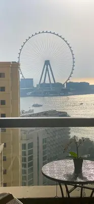 a table with a view of a ferris wheel in the background at Bahar JBR Apartment by HAPPY SEASON in Dubai