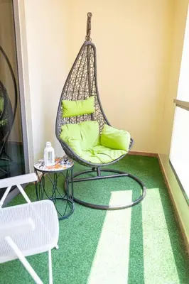 a room with a swing chair and a table at Bahar JBR Apartment by HAPPY SEASON in Dubai