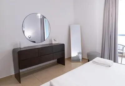 a bedroom with a mirror and two beds at BAHAR apartments on JBR by HAPPY SEASON in Dubai
