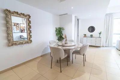 a dining room with a table and chairs and a mirror at BAHAR apartments on JBR by HAPPY SEASON in Dubai