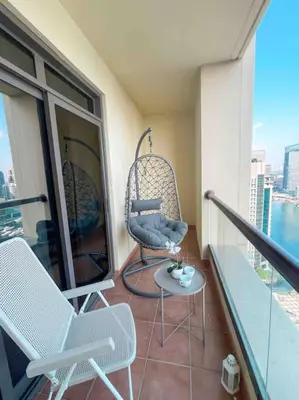 a balcony with two chairs and a table on a building at SHAMS 2 bedrooms apartment on JBR by HAPPY SEASON in Dubai