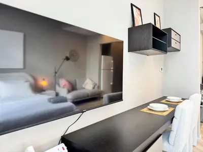 a bedroom with a bed and a desk with a mirror at Warm and Elegant Studio in Dubai in Dubai