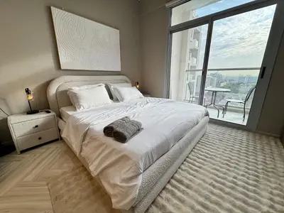 a bedroom with a large bed and a large window at Warm and Elegant Studio in Dubai in Dubai