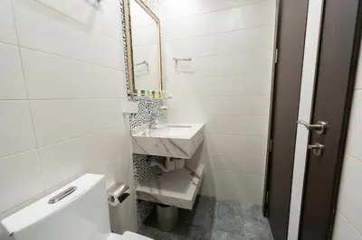 a white bathroom with a sink and a mirror at FAM Living - Bayz Tower by Danube - Business Bay in Dubai
