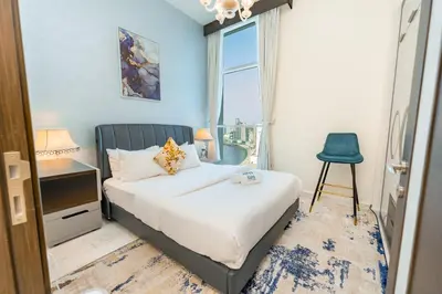 a bedroom with a bed and a chair and a window at FAM Living - Bayz Tower by Danube - Business Bay in Dubai