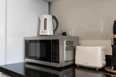 a microwave sitting on top of a kitchen counter at White Sage - Damac Ghalia JVC 35th Floor with Balcony in Dubai