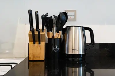 a coffee pot on a counter with a bunch of knives at White Sage - Damac Ghalia JVC 35th Floor with Balcony in Dubai