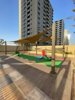 a playground in front of some tall buildings at White Sage - Damac Ghalia JVC 35th Floor with Balcony in Dubai