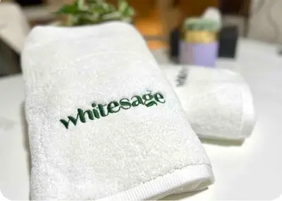 a white towel with the word wilderness written on it at White Sage - Damac Ghalia JVC 35th Floor with Balcony in Dubai