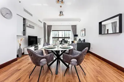 a dining room with a table and chairs in a living room at StoneTree - 1BR apartment with Beach Access Fairmont in Palm Jumeirah in Dubai