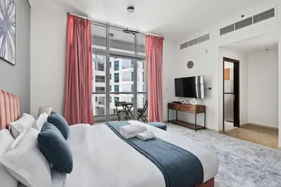 a bedroom with a large bed with red curtains at StoneTree - New Cozy Studio in Dubai Marina in Dubai