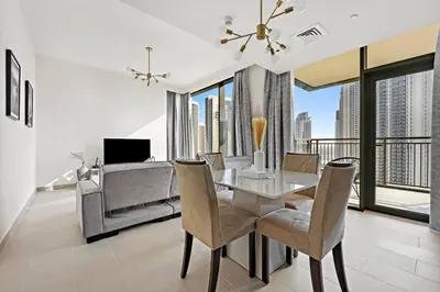 a dining room with a table and chairs and a couch at StoneTree - Elegant 1BR in amazing community in Dubai