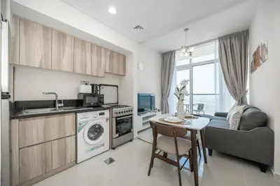 a kitchen and living room with a sink and a table at StoneTree - Cozy 1BR with spacious balcony in Golf Vita A in Dubai