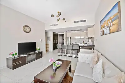 a living room with a couch and a table at StoneTree - Spacious 2BR in Peaceful Community in Dubai