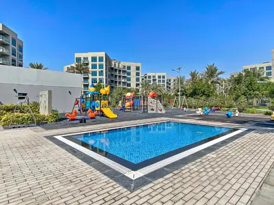 a swimming pool with a playground and a slide at StoneTree - Spacious 2BR in Peaceful Community in Dubai