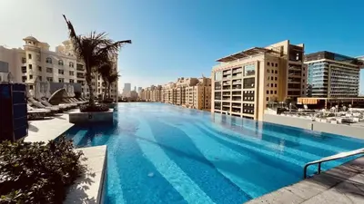 a large swimming pool in a city with buildings at StoneTree - Luxurious 1BR with Amazing Sea View in Dubai