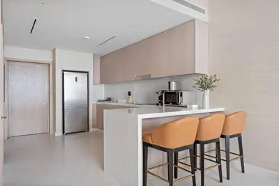 a kitchen with two bar stools and a counter at StoneTree - Luxurious 1BR with Amazing Sea View in Dubai