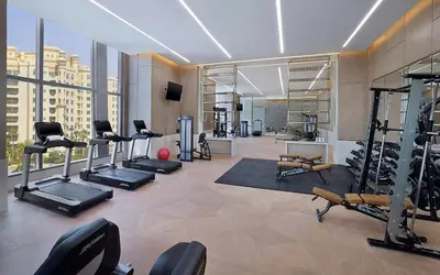 a gym with several treadmills and machines in a building at StoneTree - Luxurious 1BR with Amazing Sea View in Dubai