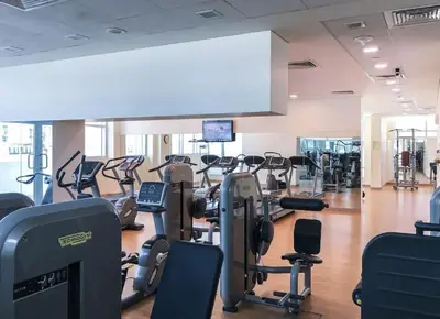 a gym with lots of treadmills and cardio equipment at StoneTree - Stylish 1BR & Pool with Burj Khalifa Views in Dubai