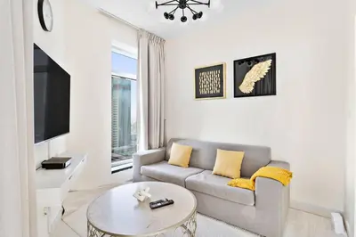 a living room with a couch and a table at StoneTree - Stylish 1BR & Pool with Burj Khalifa Views in Dubai
