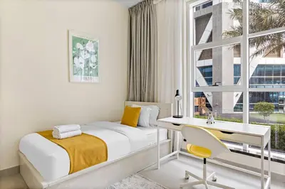a bedroom with a bed and a desk and a window at StoneTree - Furnished 2 BR with Maids Room in Dubai Marina in Dubai