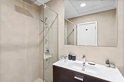 a bathroom with a sink and a shower with a mirror at StoneTree - Furnished 2 BR with Maids Room in Dubai Marina in Dubai