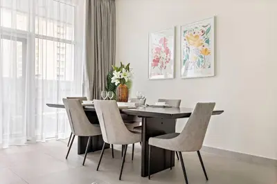 a dining room with a black table and chairs at StoneTree - Furnished 2 BR with Maids Room in Dubai Marina in Dubai