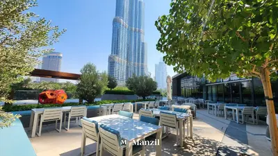 a patio with tables and chairs and a view of a city at Address Opera - Lux 3 BR with Full Burj Khalifa View near Dubai Mall in Dubai