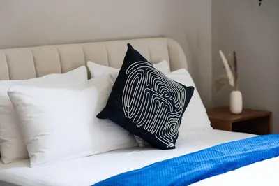 a bed with black and white pillows on it at Luxury apartment at Discovery in Dubai