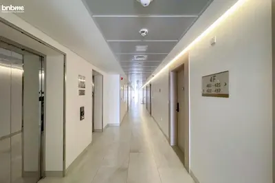 a corridor of an office building with white walls and a long hallway at bnbmehomes - Luma21 in Dubai
