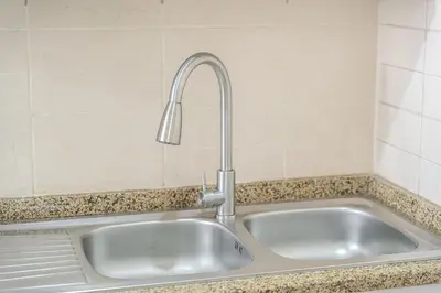 a kitchen sink with a faucet on a counter at Cozy Haven with Spiritual Charm in JLT in Dubai