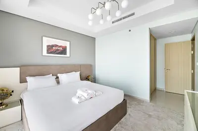 a bedroom with a large white bed with white sheets at StoneTree - Furnished 2 BR with City View in Dubai